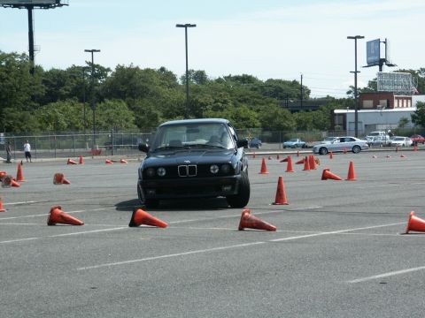 2001 Mercury Grand Marquis - A black BMW E30 sedan navigates an autocross course marked by orange cones.