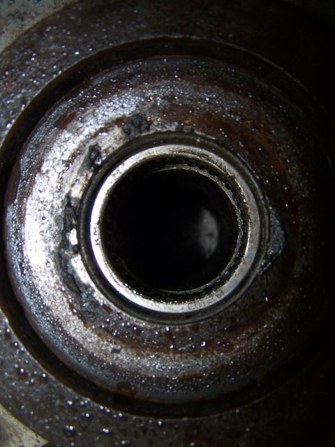1979 Ford Bronco - Worn bearing with visible rust and pitting inside a metal housing, part number KML is faintly visible.