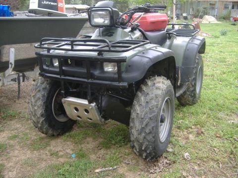 1999 Honda FOURTRAX FOREMAN S - This ATV is parked outdoors on a grassy area, with a boat on a trailer visible in the background.