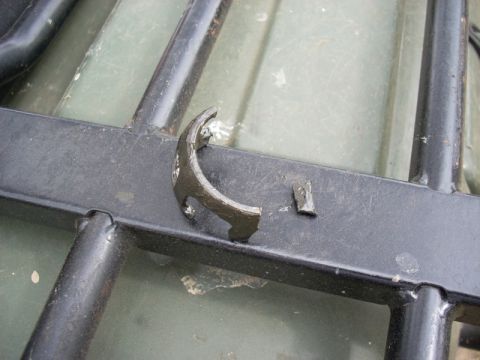 1999 Honda FOURTRAX FOREMAN S - Close-up of a damaged metal bracket on an ATV rack, with a piece broken off.