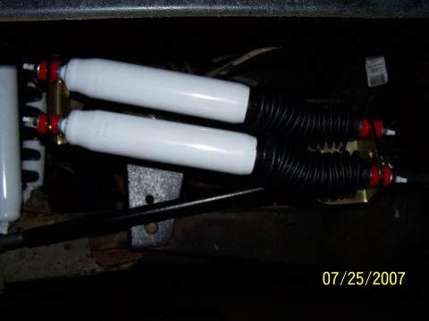 1979 Ford F-150 - Close-up view of two white rear shock absorbers with black protective bellows, dated 07/25/2007.