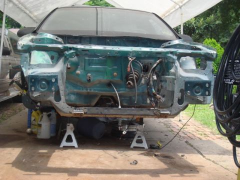 1993 Ford Taurus - Front end of a 1993 Ford Taurus disassembled for rebuild, supported by jack stands.