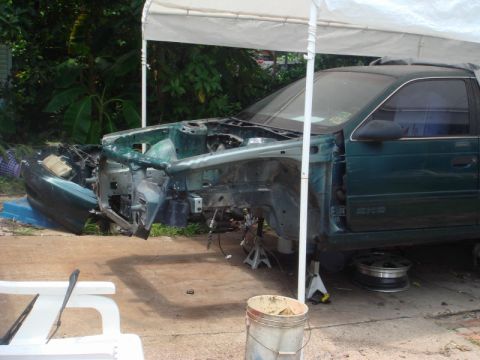 1993 Ford Taurus - This vehicle is in a state of disassembly, with its front end completely removed and parts scattered around.