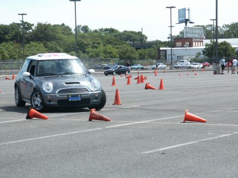 2001 Mercury Grand Marquis - A gray Mini Cooper with a Union Jack roof is seen maneuvering through an autocross course marked by orange cones.