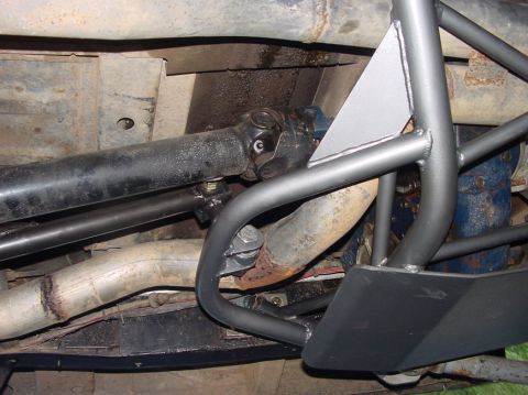 1979 Ford Bronco - Close-up view of custom roll cage and exhaust system installed on a vehicle's undercarriage.