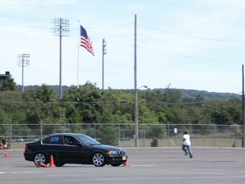 2001 Mercury Grand Marquis - A black BMW sedan with racing number 228 on its door navigates a course marked by orange cones.