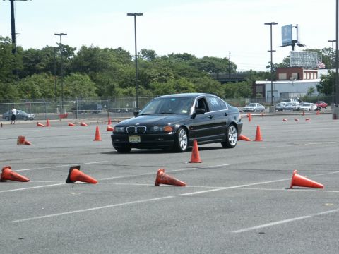 2001 Mercury Grand Marquis - BMW sedan navigates a course marked by orange traffic cones on a sunny day.