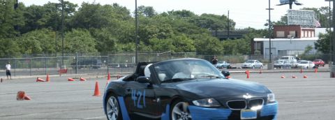 2001 Mercury Grand Marquis - A black convertible sports car with blue accents is seen on a track with orange cones.