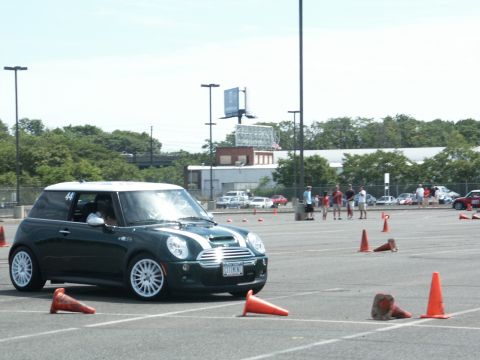 2001 Mercury Grand Marquis - A green Mini Cooper navigates an autocross course, marked by orange cones.
