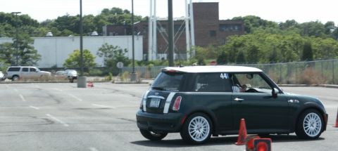 2001 Mercury Grand Marquis - A Mini Cooper navigates a course marked by traffic cones in a parking lot.