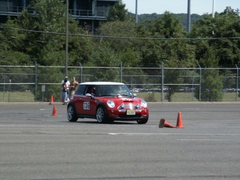 2001 Mercury Grand Marquis - A red Mini Cooper participates in an autocross event on a paved course marked with cones.