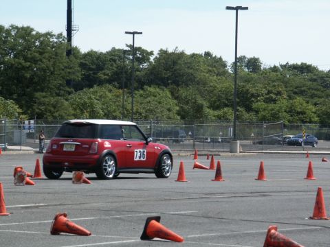 2001 Mercury Grand Marquis - A red Mini Cooper with a white roof navigates an autocross course marked by orange cones.