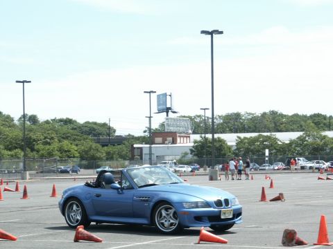 2001 Mercury Grand Marquis - Blue BMW Z3 convertible navigates a course marked by orange cones on a sunny day.