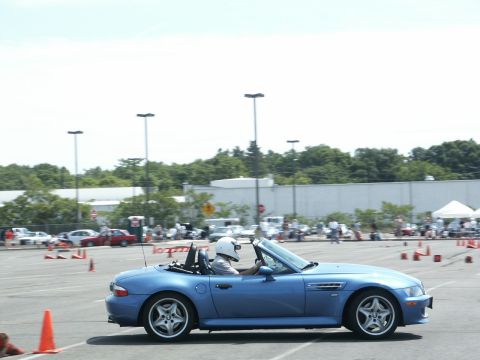2001 Mercury Grand Marquis - A blue convertible is driven around a course marked by orange cones, with spectators in the background.