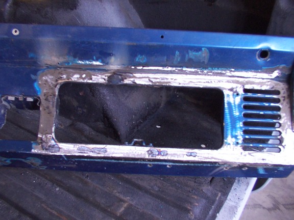 Blue Bronco panel with rectangular vent opening ground to bare metal, sitting in a truck bed during restoration