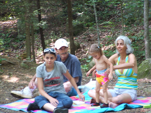Family having a picnic on a blanket in the woods