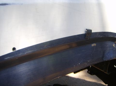 1986 Ford Bronco - Detail of a vehicle's fender trim, showing wear and a mounting clip.