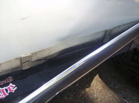 1986 Ford Bronco - Close-up of a truck bed showing a white cover, chrome trim, and a pink sticker with text.