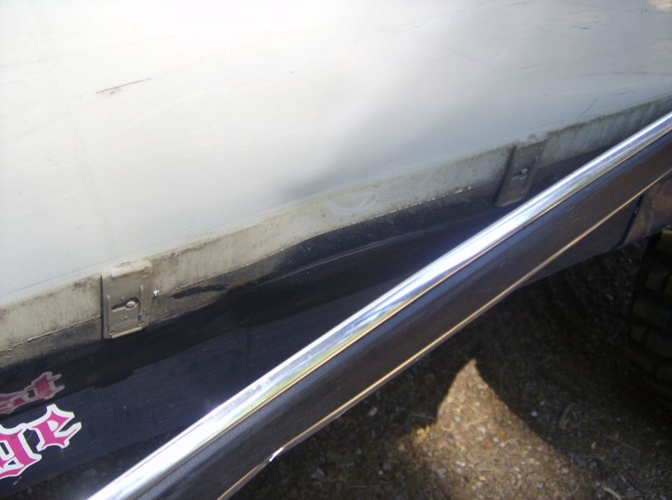 Truck bed with a white cover, chrome trim, and a pink sticker with stylized text