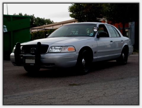 1998 Ford Crown Victoria - This 1998 Ford Crown Victoria police car features a prominent push bumper and is seen from a three-quarter front view.