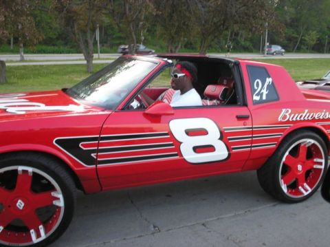 1996 Ford Bronco - A red car with racing decals, including the number 8 and Budweiser branding, is parked outdoors.