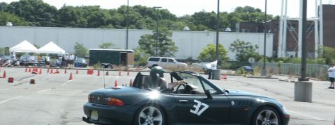 2001 Mercury Grand Marquis - A dark convertible sports car, marked with the number 37, navigates an autocross course.