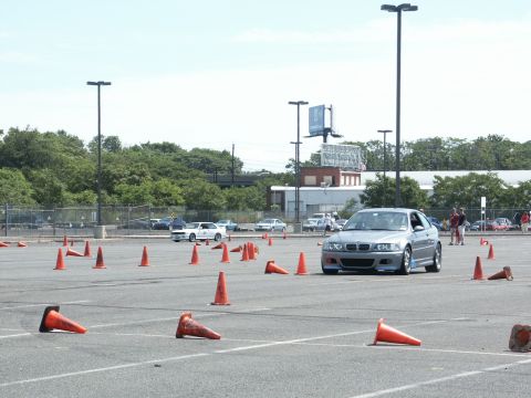 2001 Mercury Grand Marquis - A silver BMW M3 navigates an autocross course marked by orange cones.