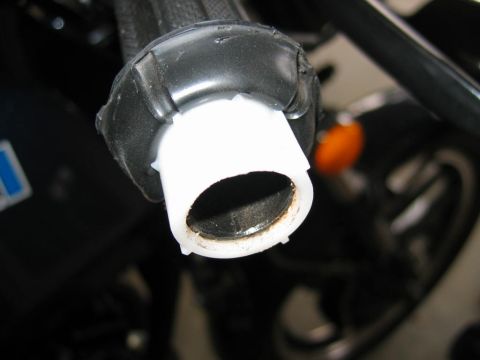 1985 Ford LTD Crown Victoria - The image shows a close-up of a motorcycle's handlebar grip, revealing a white plastic insert and some dirt accumulation.