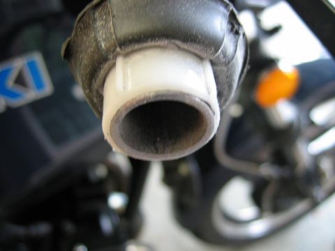 1985 Ford LTD Crown Victoria - A close-up view of a motorcycle's exhaust pipe, showing wear and tear.