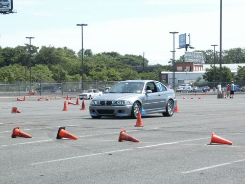 2001 Mercury Grand Marquis - A silver BMW M3 coupe navigates an autocross course marked by orange cones.