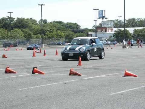2001 Mercury Grand Marquis - A green Mini Cooper participates in an autocross event on a sunny day, with orange cones marking the course.