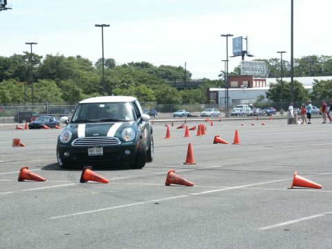 2001 Mercury Grand Marquis - A Mini Cooper navigates a cone course in a parking lot on a sunny day.