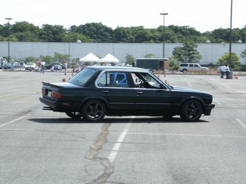 2001 Mercury Grand Marquis - Side view of a black sedan with racing numbers on the windows, possibly at an event.