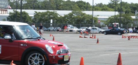 2001 Mercury Grand Marquis - A red Mini Cooper is positioned on a paved lot marked with orange cones for a driving event.