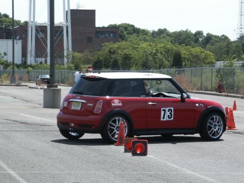 2001 Mercury Grand Marquis - A red Mini Cooper with a white roof and racing number 73 navigates an autocross course.