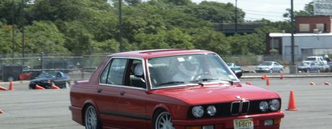 2001 Mercury Grand Marquis - A red BMW sedan navigates an autocross course, with other vehicles visible in the background.
