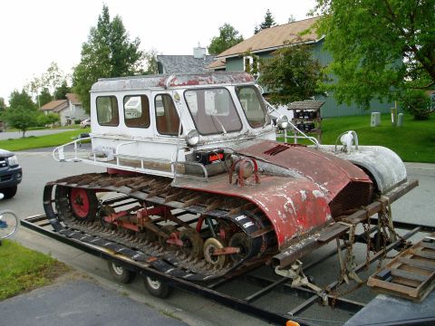 2000 Ford E350 - This tracked vehicle, likely a snowcat, is being transported on a trailer.