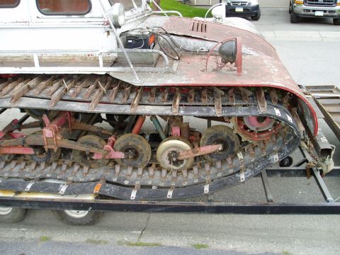 2000 Ford E350 - This tracked snow vehicle, likely not a 2000 Ford E350, is shown from the side while on a trailer.