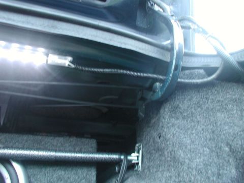 1990 Ford Thunderbird - Close-up view of the trunk's interior, showing an aftermarket LED light strip and carpeting.