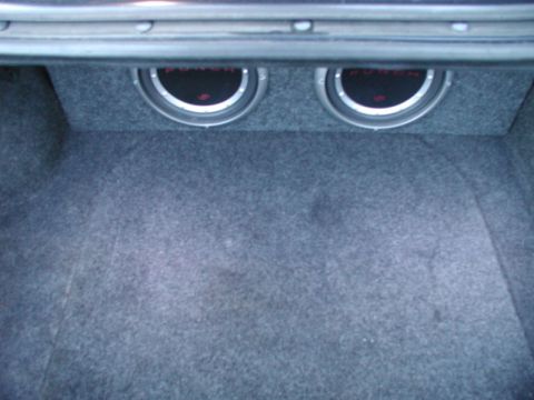 1990 Ford Thunderbird - The trunk of a car contains a custom enclosure with two subwoofers.