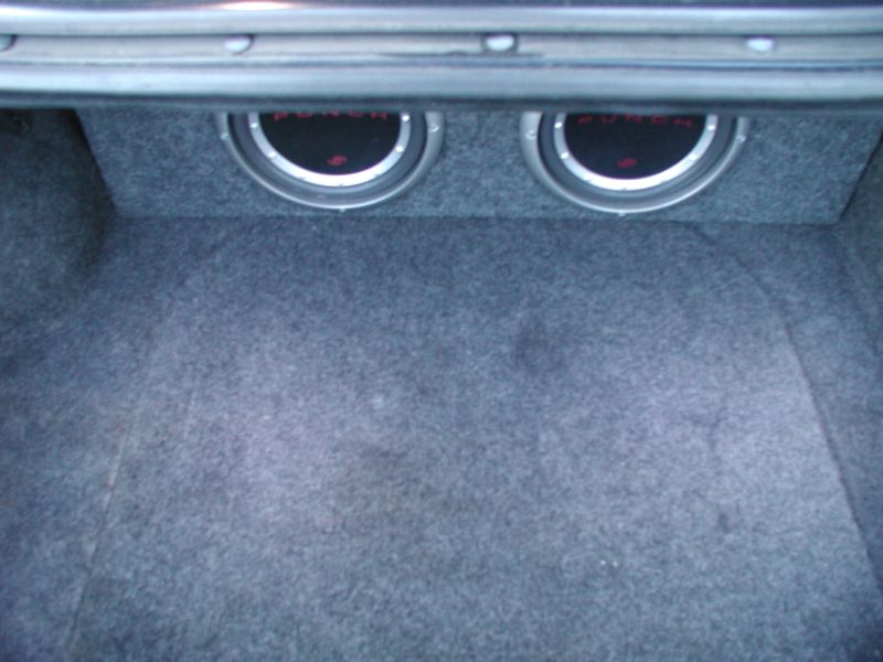 Two Rockford Fosgate Punch subwoofers in a carpeted box inside a car trunk