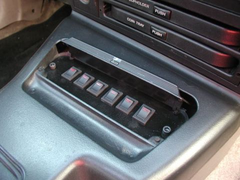 1990 Ford Thunderbird - Center console auxiliary switch panel and coin tray assembly from a car interior.