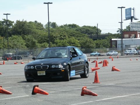 2001 Mercury Grand Marquis - A black BMW M3 navigates an autocross course marked by orange cones.