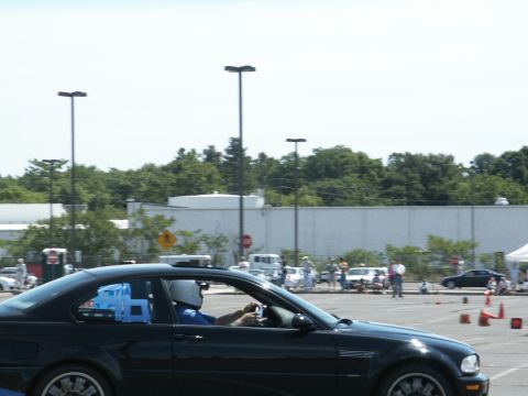 2001 Mercury Grand Marquis - A black coupe with a driver wearing a helmet participates in an event with other vehicles and cones visible.