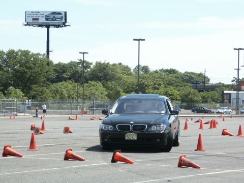 2001 Mercury Grand Marquis - BMW sedan maneuvers through an autocross course with orange cones marking the path.