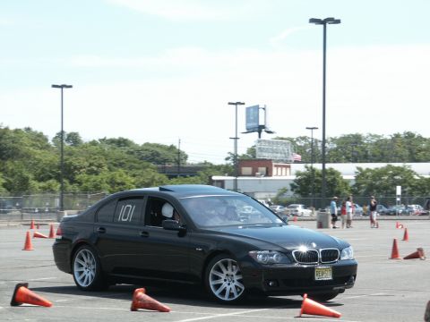 2001 Mercury Grand Marquis - A black BMW 7 Series sedan navigates an autocross course marked by orange cones on a sunny day.