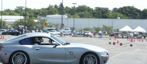 2001 Mercury Grand Marquis - A silver BMW Z4 coupe navigates an autocross course with cones set up in a parking lot.