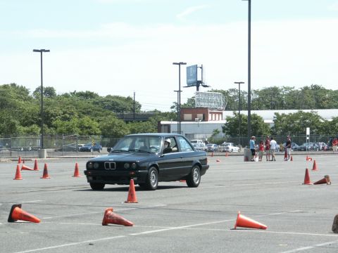 2001 Mercury Grand Marquis - A black coupe navigates an autocross course marked by orange cones on a sunny day.