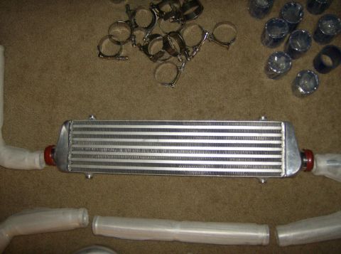 1996 Ford Probe - An intercooler kit with piping and clamps is laid out on a carpeted surface.