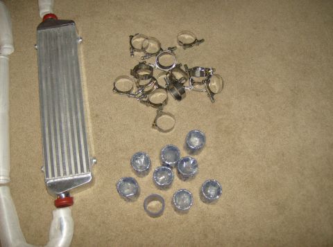 1996 Ford Probe - An intercooler and a pile of hose clamps are laid out on a carpeted surface, with a Supermotors.net watermark in the corner.